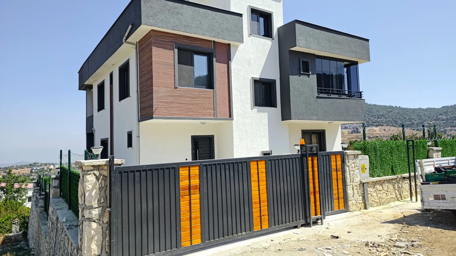 Müstakil evde antrasit ve ahşap görünümlü yana kayar bahçe kapısı